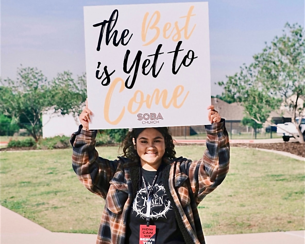 Community member holding Soba Church sign