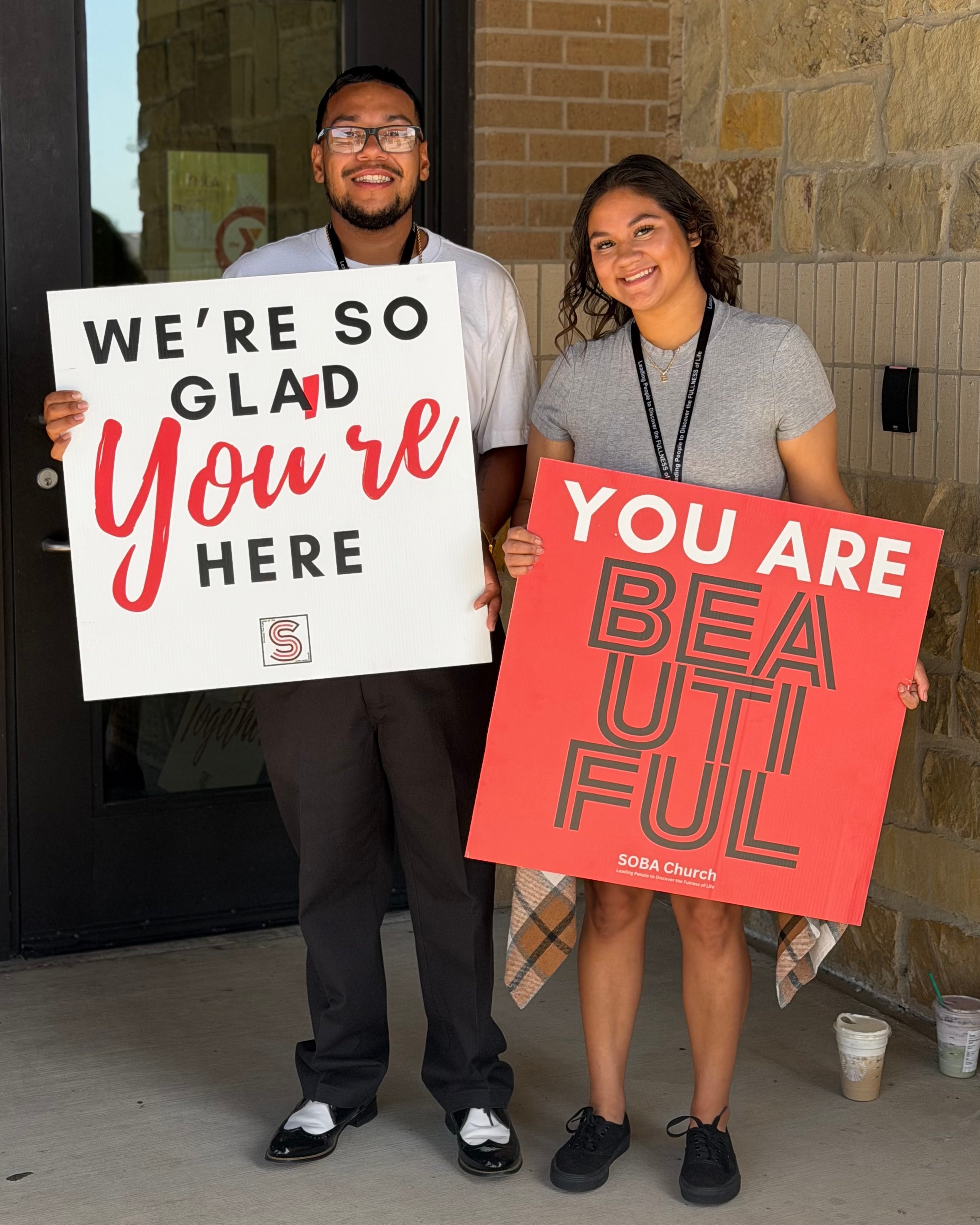 Soba Church greeters welcoming visitors with signs